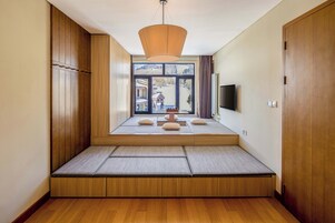 Una habitación con zona de estar integrada, televisión y ventana con vistas a un paisaje nevado.