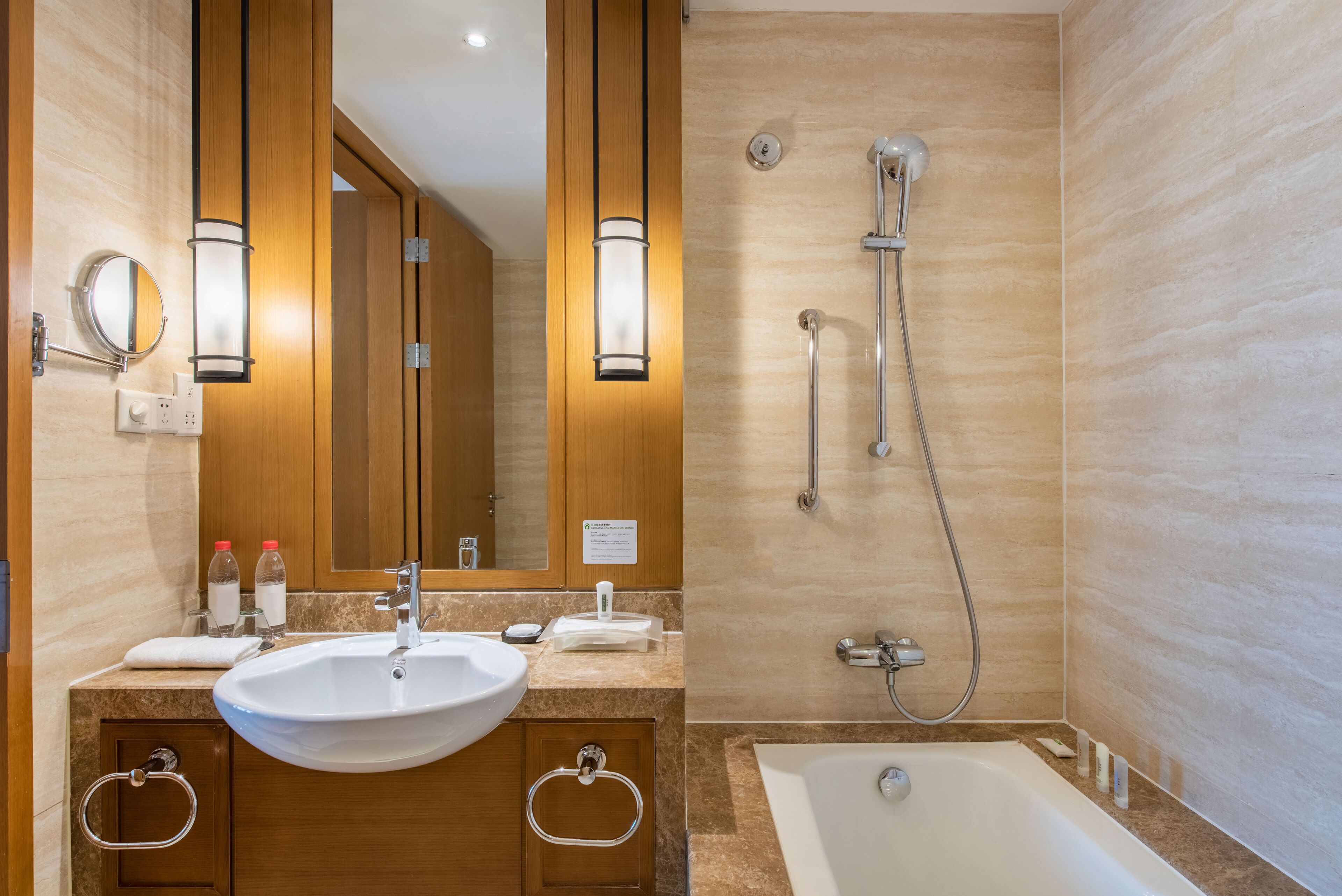 Un baño moderno con lavamanos, espejo y ducha.