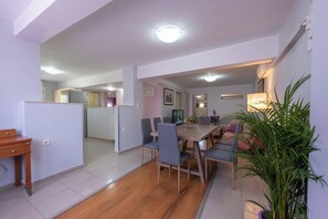 Relax in this stylish living space with a dining table, sofa, and TV.