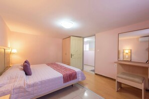 Cozy retreat with a single bed, bedside table, and mirror.