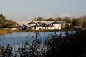 Stunning lakeside buildings with a modern architectural style, set amidst lush vegetation.