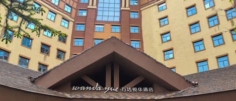 A hotel with a prominent entrance, multiple floors, and a large sign above the entrance.