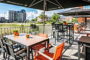 Relax in style on this outdoor patio with comfortable seating, umbrellas, and city views.