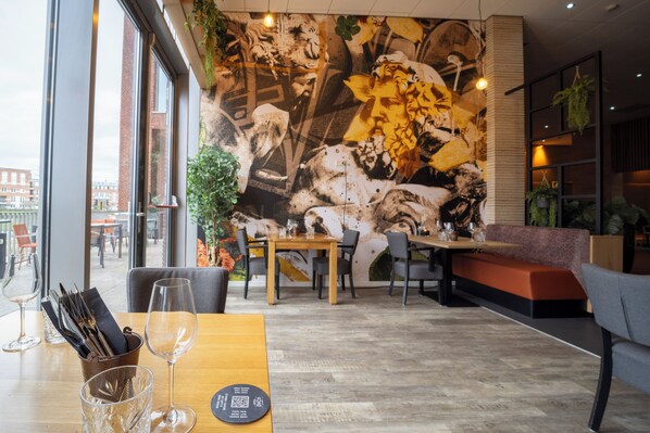 Enjoy meals in a stylish dining area with a large mural and comfortable seating.