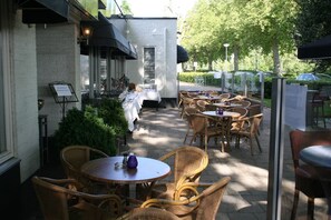 Relax in our outdoor seating area, surrounded by lush greenery and comfortable wicker chairs.
