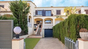 Una casa de dos pisos con un camino de entrada pavimentado que conduce a un garaje.