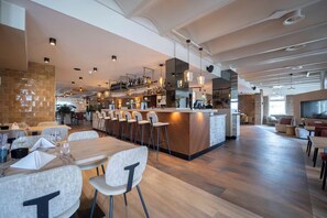 Enjoy a casual dining experience with a long dining table, bar area, and comfortable seating.