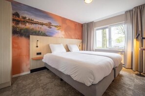 Relax in a serene space with a large bed and calming views, surrounded by simple, modern design.