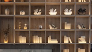 A modern living room with a sofa, coffee table, and a bookshelf filled with various decorative items. - Wanda Moments Xitang (Jiaxing)