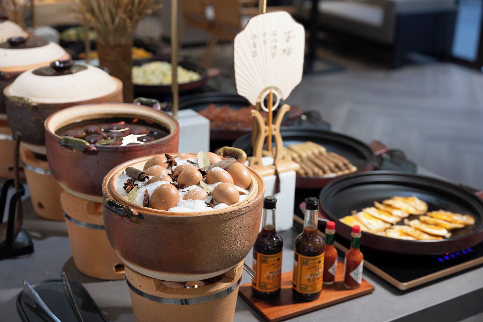 Ein Buffet mit verschiedenen Speisen, darunter eine Schüssel mit Eiern, Beilagen und ein Grill.