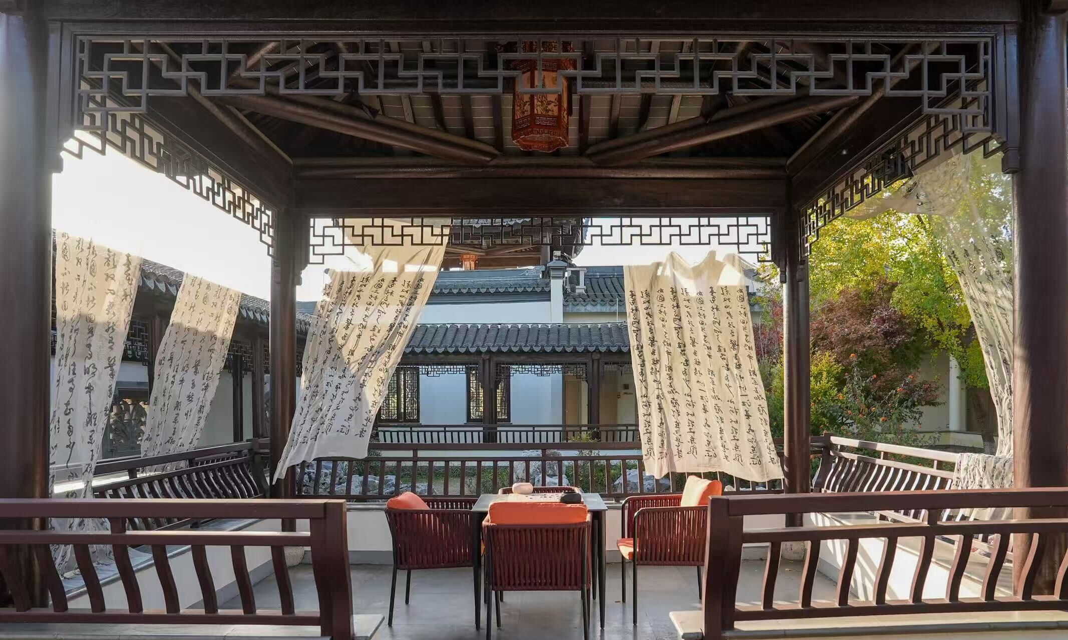 Un balcon de style chinois traditionnel, avec des balustrades en bois et une table entourée de chaises.