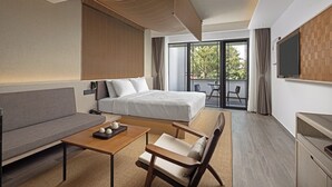 A modern hotel room with a bed, sofa, and a small table with teapots. There is a balcony with a view of trees. - Wanda Moments Xitang (Jiaxing)