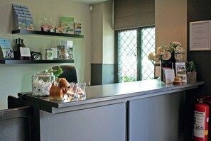 Welcome to our reception area, where friendly staff are available to assist with your stay. The reception desk offers a computer and telephone for your convenience.