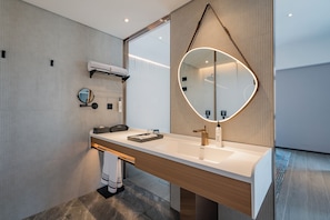 A modern bathroom with a large mirror, a white sink, and a towel rack. - Wanda Moments Cixi (Ningbo)