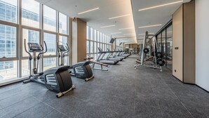 Un gimnasio con cintas de correr, máquinas elípticas y equipo de levantamiento de pesas.