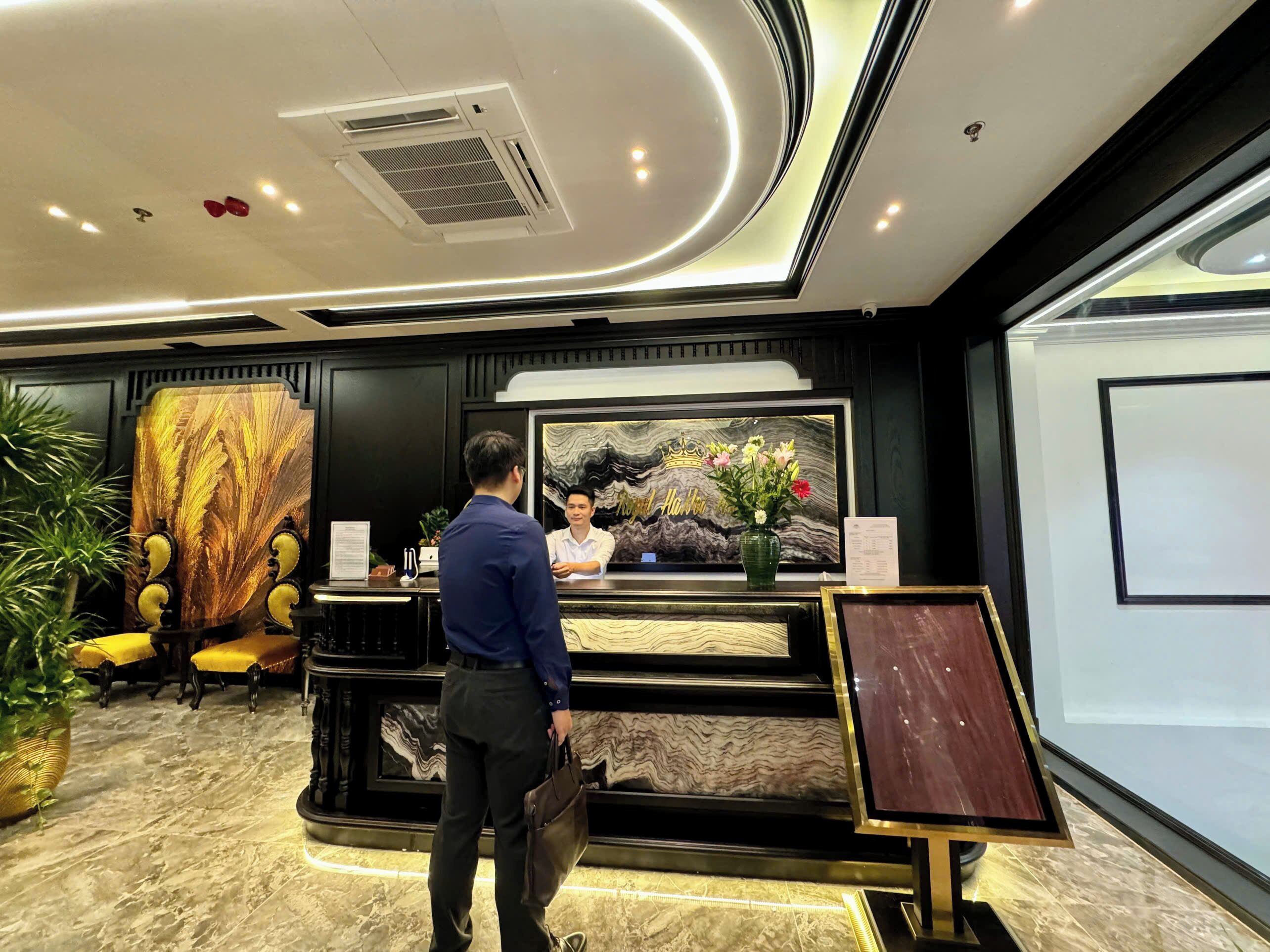 A reception area with a marble floor, a reception desk, a framed artwork, and a plant.