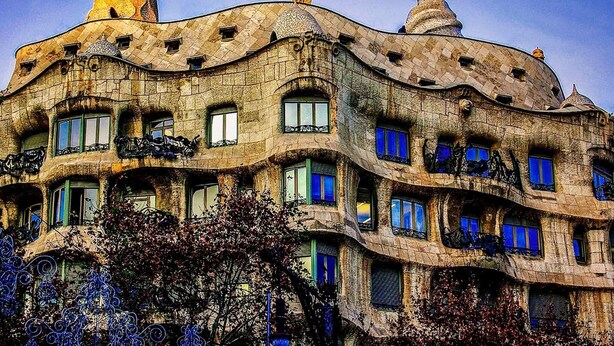 A building with a unique, wavy facade and multiple balconies. - Charming Stone House near Beach Retreat (Vilaür)