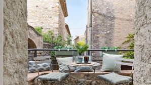 A cozy outdoor seating area with a round table, two chairs, and a small potted plant. - Charming Stone House near Beach Retreat (Vilaür)