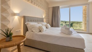 A bedroom with a large bed, a view of the outdoors, and a geometric wall pattern. - Villa Regina on the Sea (Carovigno)