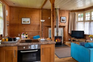 A cozy cabin interior with a kitchen, dining area, and living room. - Cottage by Mawddach Trail with Stunning Views (Dolgellau)