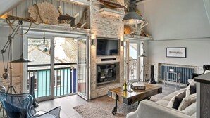 A spacious living room with a fireplace, a television, and a balcony with a view of the city. - Apartment in Dartmouth near Waterfront (Dartmouth)