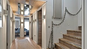 A modern interior with a wooden staircase, a hallway leading to a living area, and a chain on the wall. - Apartment in Dartmouth near Waterfront (Dartmouth)