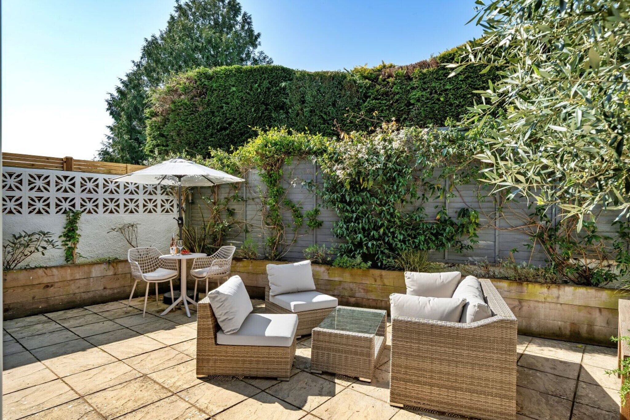 An outdoor patio with wicker furniture, a table, and chairs.