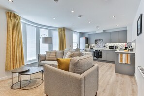 A modern apartment with a living room, kitchen, and dining area.