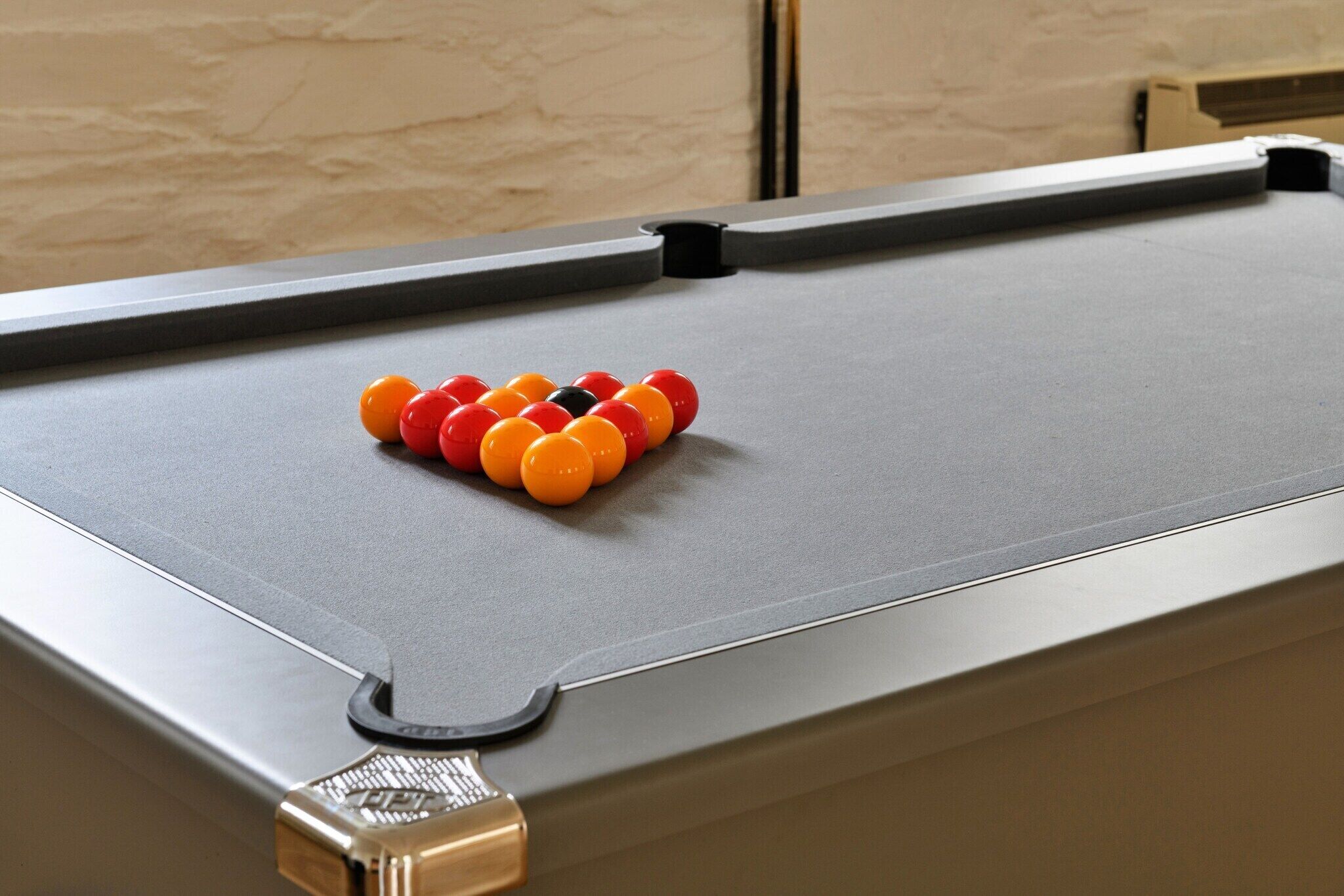A pool table with a set of balls arranged in a triangle formation.
