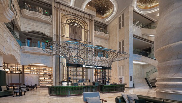 Un hall d’entrée spacieux avec un bar central, de nombreux espaces pour s’asseoir et un magnifique escalier.
