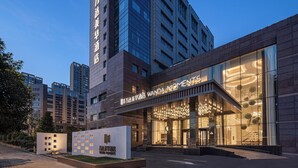 Un hôtel moderne doté d’une entrée imposante, de grandes fenêtres en verre et d’une façade bien éclairée.