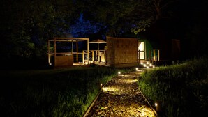 A modern outdoor structure with a glass enclosure and a wooden building, connected by a pathway. - Chalet in Kent with Hot Tub & Countryside Views (Hoath)