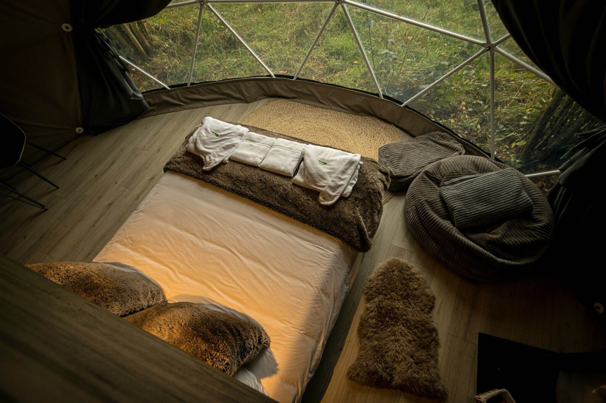 Une tente confortable avec un lit, des oreillers et une couverture.