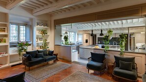 A spacious living room with a large window, a kitchen with a central island, and a dining area.