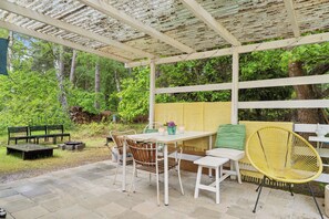 Un patio al aire libre con una mesa, sillas y un banco.