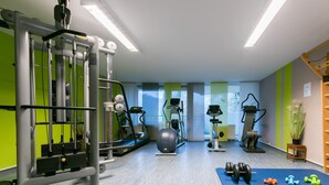 A gym with various exercise equipment, including treadmills, elliptical machines, and free weights. - Appartement im Panoramic Hotel Bad Lauterberg (Bad Lauterberg)