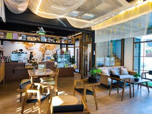 A cozy cafe with wooden furniture, a world map on the wall, and a coffee machine. - Moon in 9 haus Cafe & Villas (Rayong)