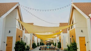 A courtyard with a pool table, outdoor seating, and string lights. - Moon in 9 haus Cafe & Villas (Rayong)