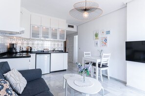 Een moderne keuken met witte kasten, een zwart aanrecht en een bijzondere hanglamp.