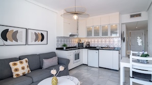 A modern kitchen with white cabinets, a built-in oven, and a microwave. - Verano Azul Seasun 90B by Casasol (Nerja)