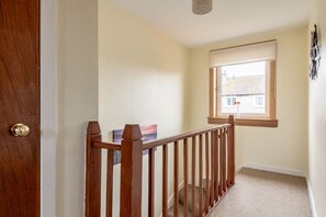 Eine Holzhandlauf-Treppe führt zu einer Aussichtsplattform mit einem Fenster.