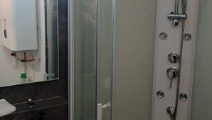 A modern bathroom with a glass-enclosed shower, a white sink, and a mirror. - COSY & MODERN STUDIO NEAR PORT (Agde)