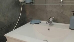 A bathroom with a white sink, two drawers, a mirror, and a soap dispenser. - COSY & MODERN STUDIO NEAR PORT (Agde)