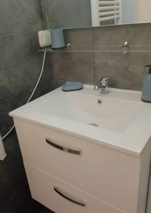 Een haardroger, handdoeken, zeep, toiletpapier