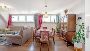 Un salon comprenant un canapé, une table à manger, des chaises et un buffet.