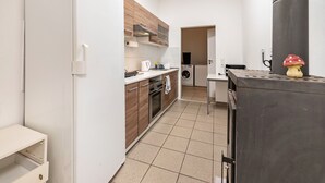A kitchen with a washing machine, a stove, and a microwave. - Holiday Apartment “SaarGlück” with Mountain Views and Wi-Fi (Beckingen)