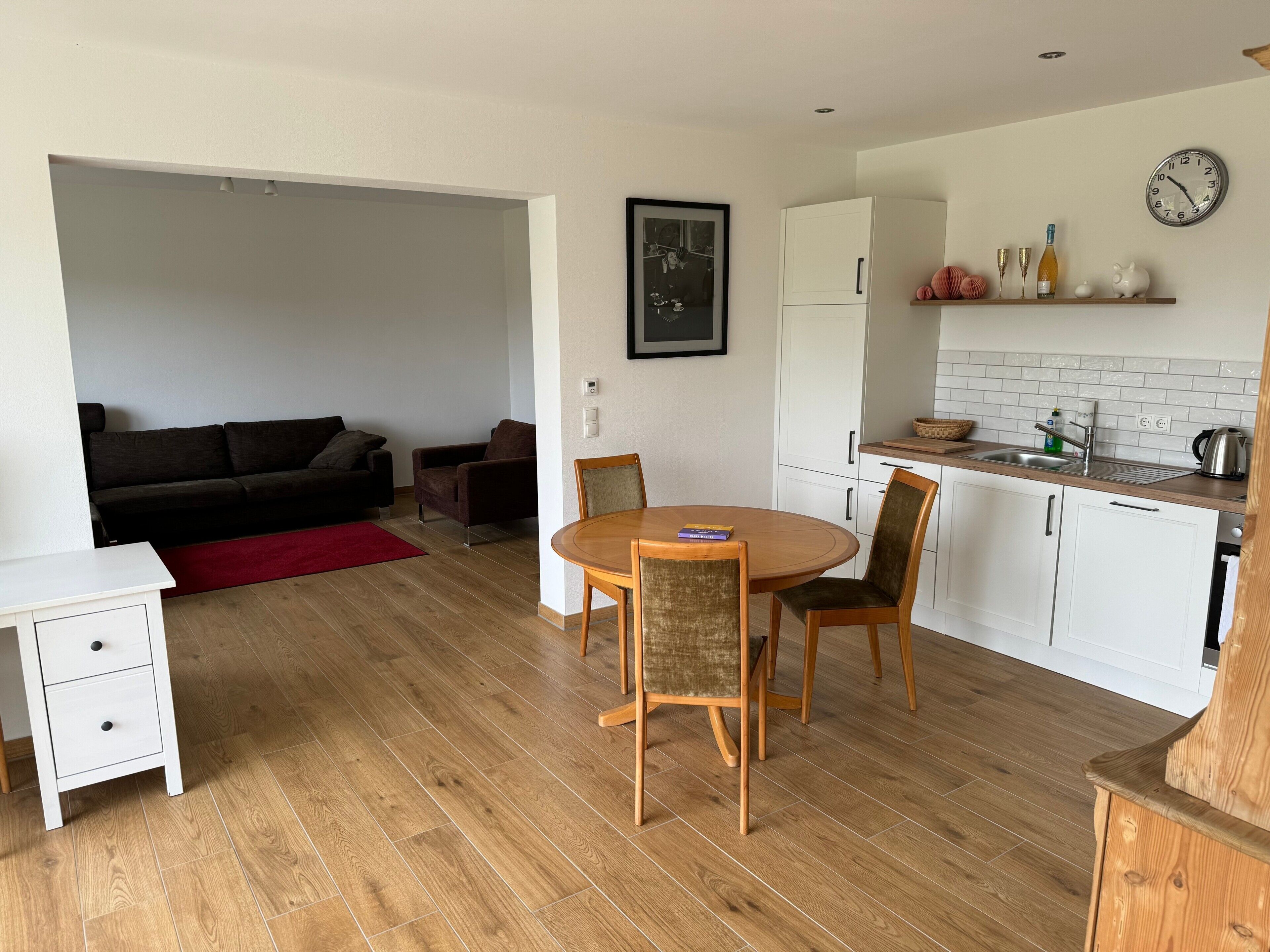 A compact living space with a dining area, kitchenette, and a sofa.