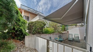 A covered outdoor area with a concrete wall, a small table, and two chairs. - Apartment '2' with Private Terrace and Wi-Fi in Endingen (Endingen)