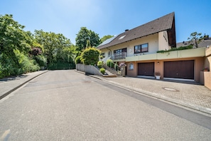 A residential street with a two-story house featuring a balcony, a driveway, and a well-maintained garden. - Apartment '1' with Terrace and Wi-Fi (Endingen am Kaiserstuhl)