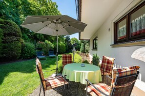 An outdoor patio with a table and chairs, surrounded by greenery. - Apartment '1' with Terrace and Wi-Fi (Endingen am Kaiserstuhl)
